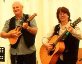 Allan on mandolin and Gay on guitar in a marquee at an 'American' themed corporate event in Windsor.