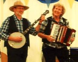 Keith on banjo and Dei on accordion in a marquee at an 'American' themed corporate event in Windsor.